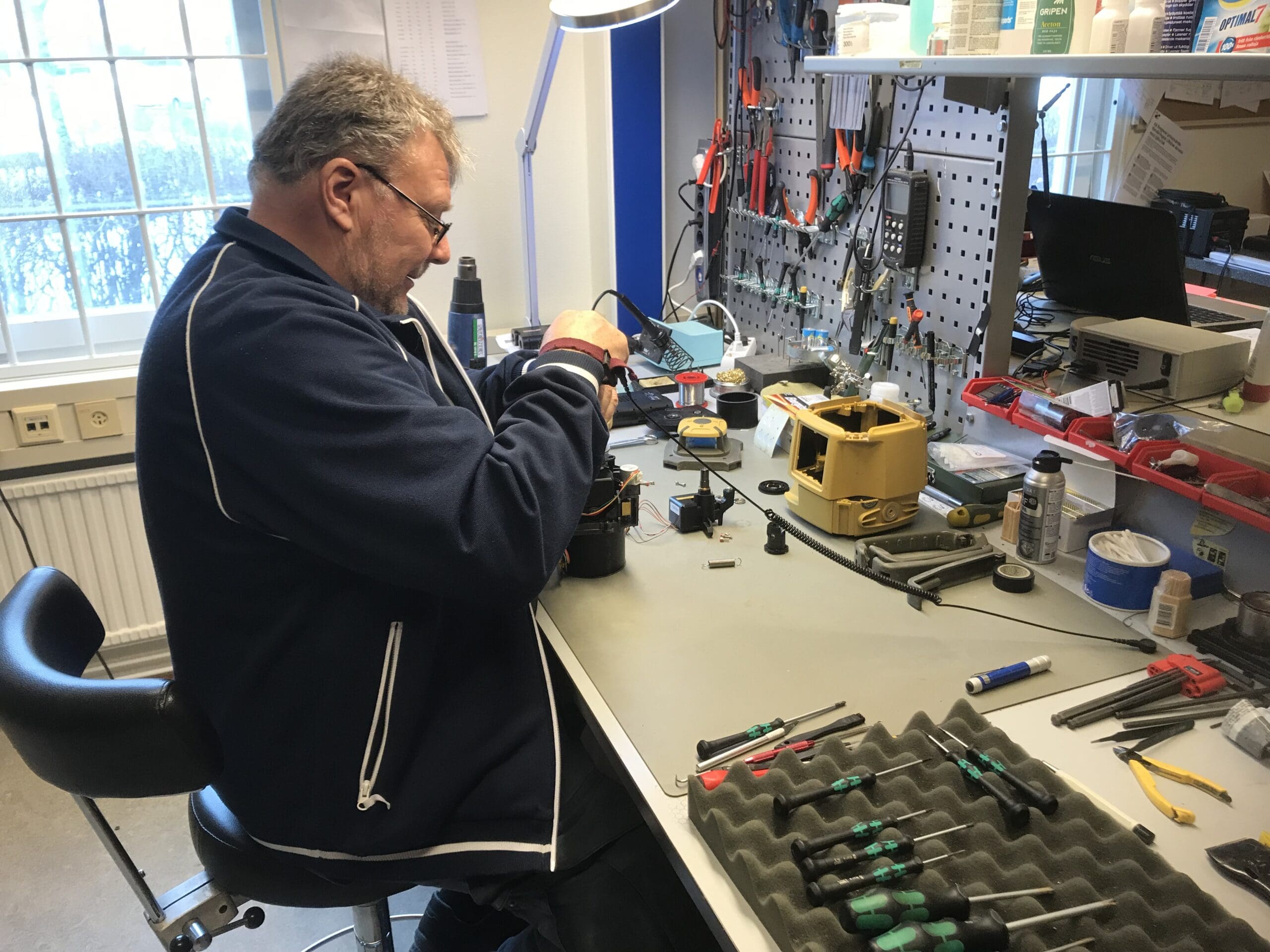 a man sitting at a desk with tools